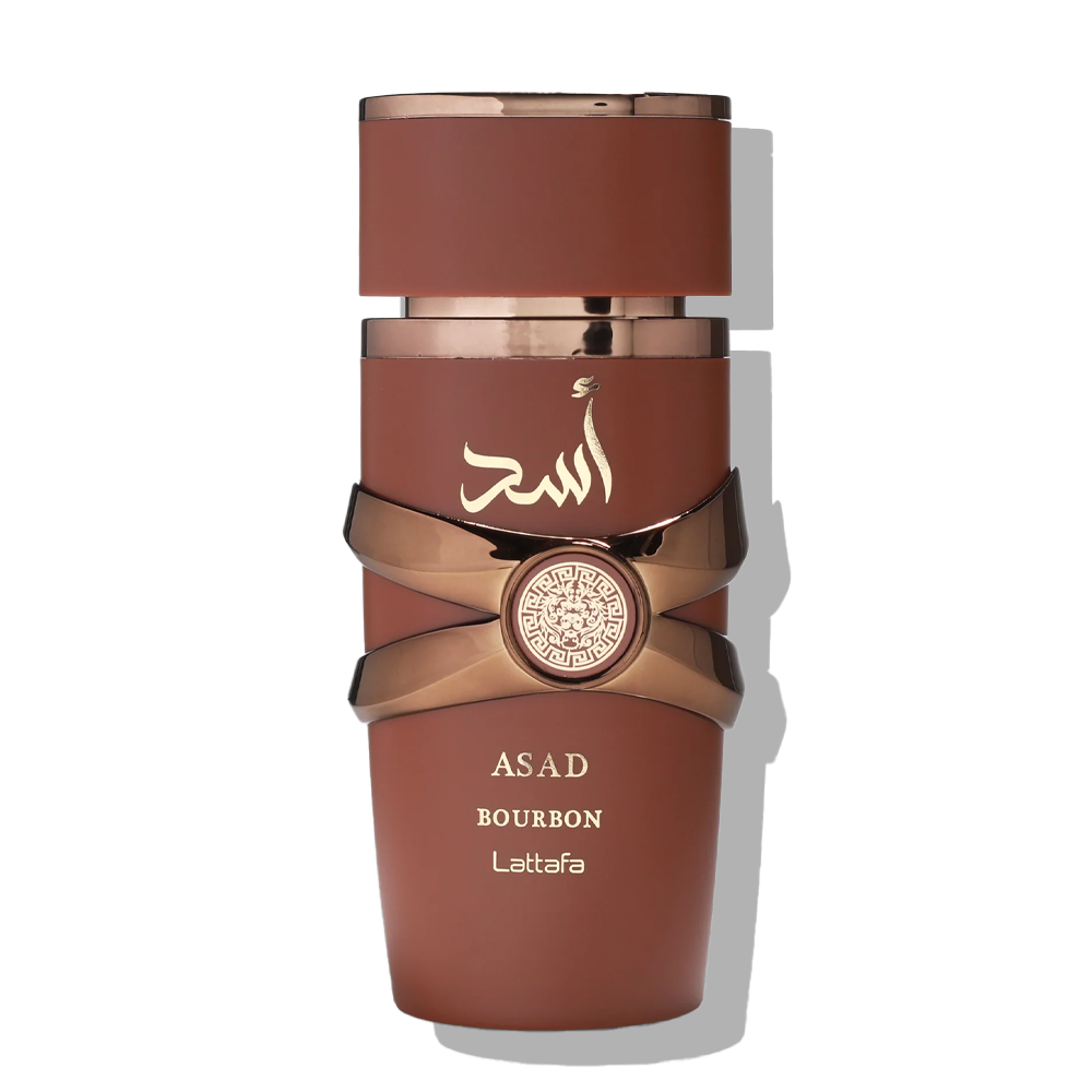 A bottle of Asad Bourbon Leatafa perfume or cosmetic product in a matte reddish-brown color with metallic rose gold accents, including a ribbon detail and a circular emblem, on a white background.